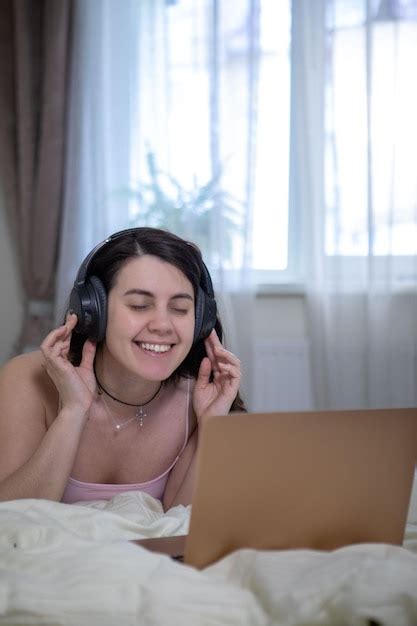 Premium Photo Woman Laying Down In Bed Working On Laptop Listening Music In Headset