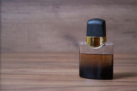 A Bottle Of Dark Cologne Standing On A Wooden Table Stock Photo Image