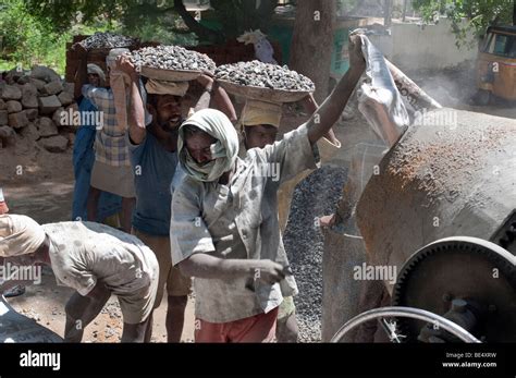 Indian Construction Workers Mixing Rock Sand And Cement To Make Stock