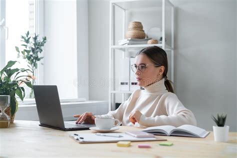 Concentrated Modern Business Woman Sitting At Office Desk And Working