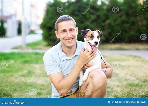 狗和它的所有者之间的密切的关系 愉快的所有者走与一个可爱的杰克罗素狗和拥抱在绿叶o 库存照片 图片 包括有 敬慕 愉快 151405104