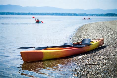 Kayak On The Sea Shore With Kayakers In The Background Stock Image