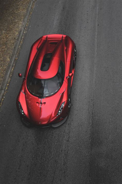 a red sports car driving down the road
