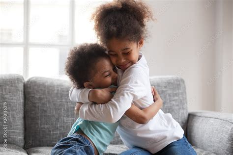Cute Happy African American Siblings Hugging Cuddling Feeling Love And