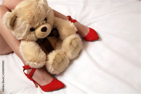 Sexy Female Legs In Red Shoes On High Heels And Teddy Bear On The Bed Romantic Christmas Gift