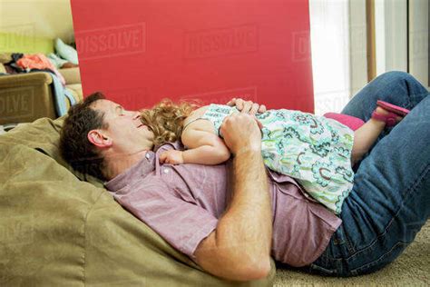 Father And Daughter Relaxing In Living Room Stock Photo Dissolve