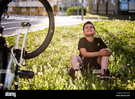 Teenage Boy There Is A Knee Injury As The Bike Falls While Riding Kid