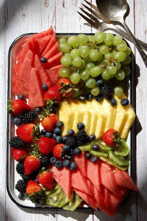 A Tray Filled With Different Types Of Fruits And Veggies Next To A Fork