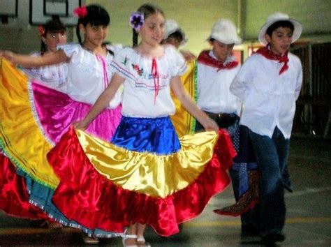 Several People In Colorful Dresses And Hats Are Dancing