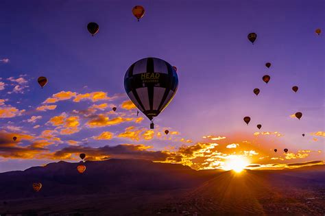 Hot Air Balloons Flying At Sunrise With The Sandia Mountains In The