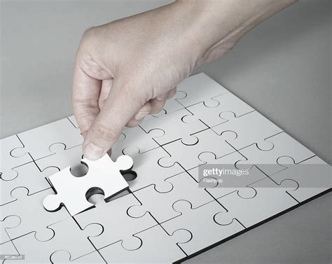 Hand Placing Last Piece Into Jigsaw Puzzle High Res Stock Photo Getty