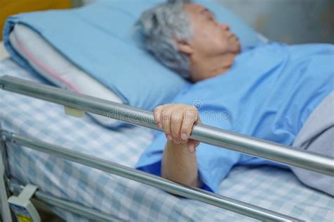 Asian Senior Or Elderly Old Woman Patient Lie Down Handle The Rail Bed
