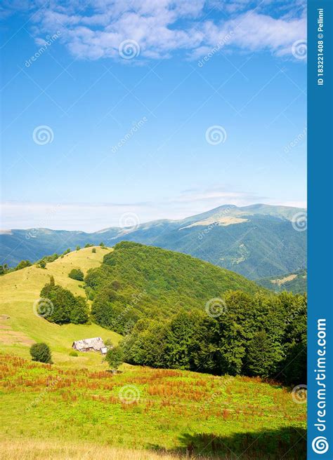 Mountain Landscape With Green Meadow On The Hill Fluffy Clouds On The
