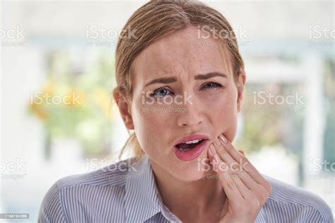 Portrait Of Young Woman Suffering With Toothache Touching Jaw Stock