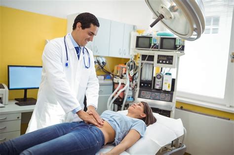 Premium Photo Doctor Examining The Stomach Of A Female Patient