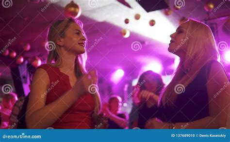 Girlfriends Dancing At A Party In A Crowd Of People Two Blondes Have