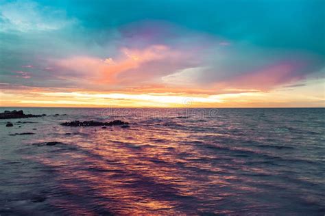 Colorful Sunset Over Water With Seagulls On Rocks Stock Photo Image