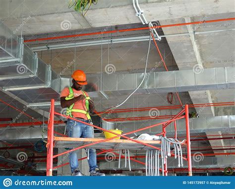 This is not a user guide or tutorial on electrical wiring. Construction Workers Installing Electrical Cable Tray And Doing Wiring Works Editorial ...