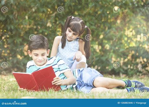 Kids Reading A Book Outdoors Stock Photo Image Of Imagination