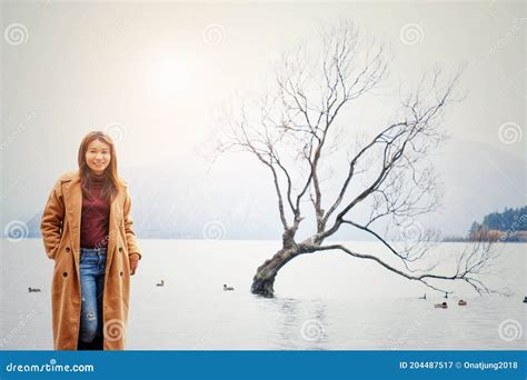Woman At The Famous Wanaka Tree Or Lonely Tree Of Wanaka At Lake