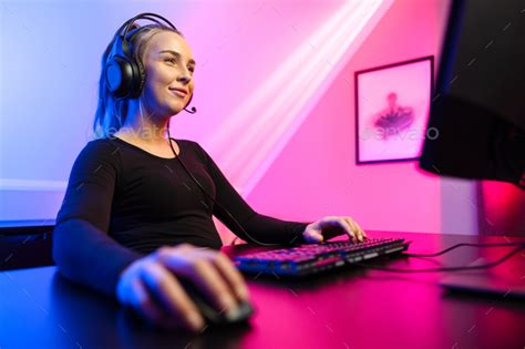 Happy And Beautiful Blonde Gamer Girl Playing Online Video Game On Her Personal Computer Stock