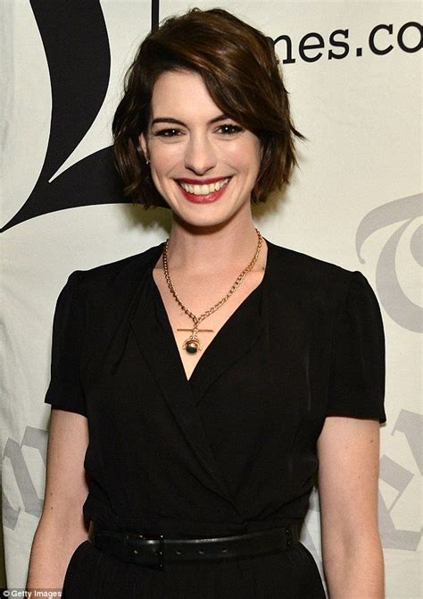 A Woman With Short Hair Wearing A Black Shirt And Smiling At The Camera