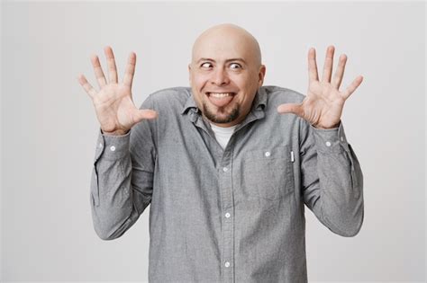 Free Photo Funny And Silly Bald Guy Show Funny Faces And Raise Hands Up