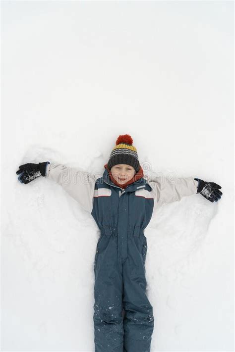 Happy Child Boy Playing On Winter In The Snow Kid Making Snow Angel