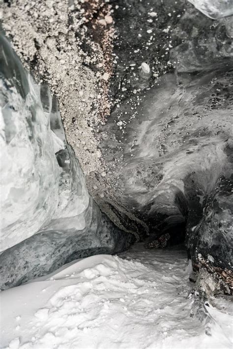 Inside Of An Ice Cave With Snow On The Ground And Rocks On Top End Of