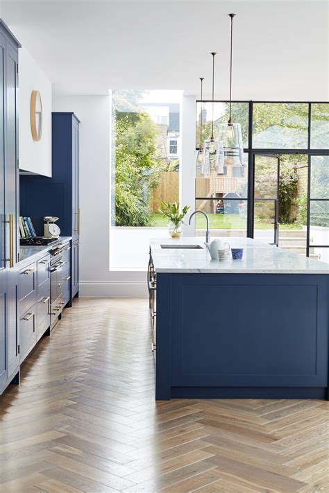 Everything home for every budget. A deep blue kitchen in an open plan kitchen design with a ...
