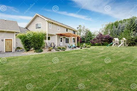 Beautiful House Backyard With Well Kept Lawn And Patio Area Stock Photo