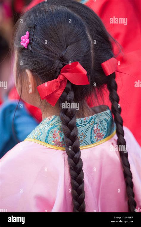 Young Girl With Long Braids And Red Ribbons In Her Hair Participates In