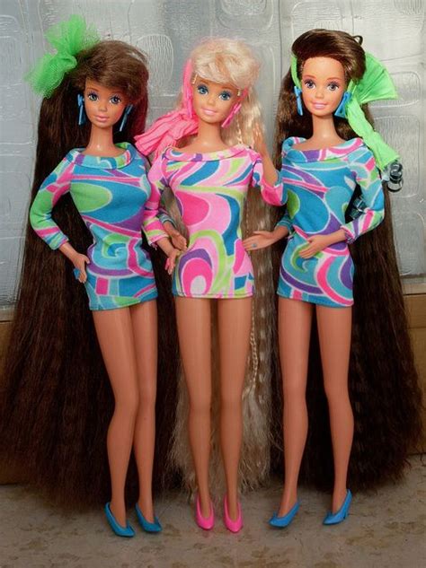 Three Barbie Dolls Standing Next To Each Other