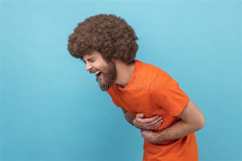 Side View Of Laughing Man Holding His Stomach And Hunched In Crazy Hysterical Laughter Stock