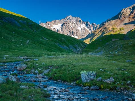 Alpine Stream In Idyllic Valley Amid Rocks And Green Meadows Natural