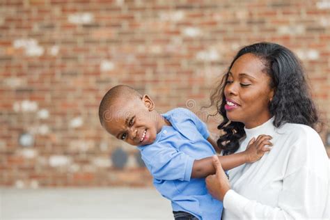 A Beautiful African American Mom Giving Her Preschool Age Son A Hug