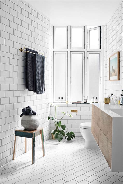 Subway tiles are beloved for their timelessness, so keep things classic with a white repeating bond pattern. scandi bathroom with angled subway floor tiles - Tile Mountain
