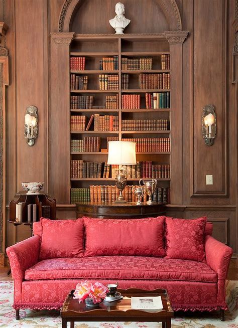 A Living Room With Red Couches And Bookshelves