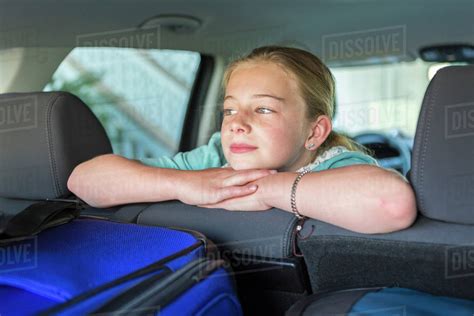 Caucasian Girl Sitting In Car Back Seat On Road Trip Stock Photo
