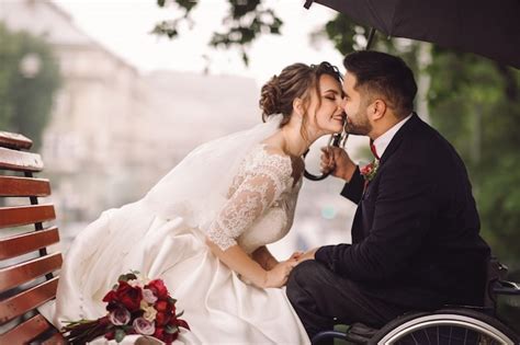 Braut Und Bräutigam Auf Dem Rollstuhl Sitzen Küssend Auf Der Bank Im Park Kostenlose Foto