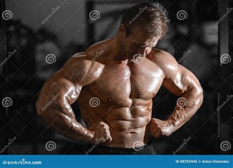 Brutal Strong Bodybuilder Man Pumping Up Muscles And Train Gym Stock