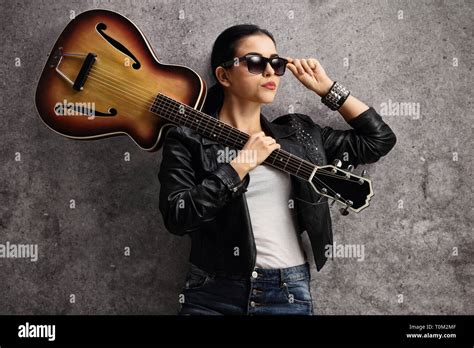 Female Guitar Player Leaning On A Rusty Gray Wall Stock Photo Alamy