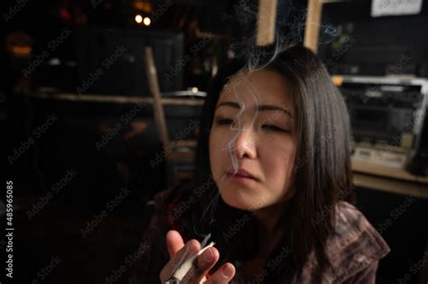 Asian Girl Smoking A Weed Joint Getting High Inhaling And Exhaling Weed