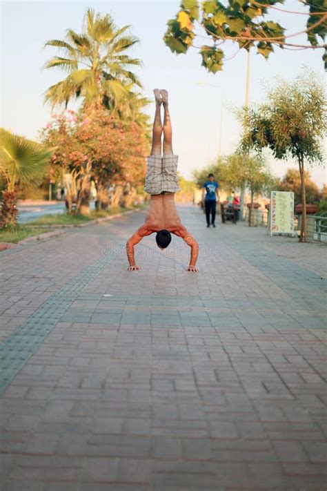 Man Showing Impressive Strength Doing A Handstand In Street Stock