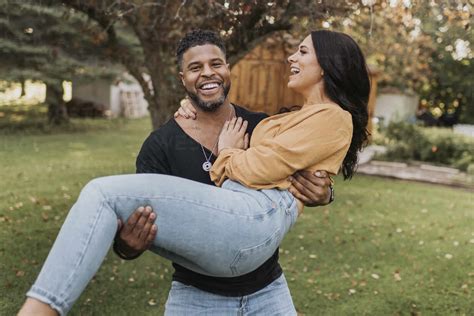 Smiling Man Carrying Woman In Arms While Standing At Backyard Stock Photo