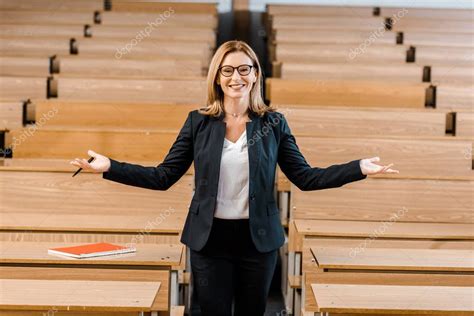 happy female university professor outstretched hands looking camera classroom st affiliate