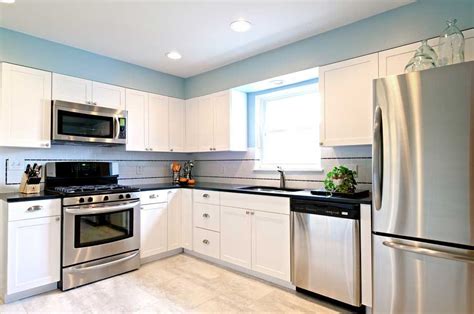 Think white cabinets above the sink paired with shades of blue, black, or brown below. stainless steel in a white kitchen - Google Search | White ...