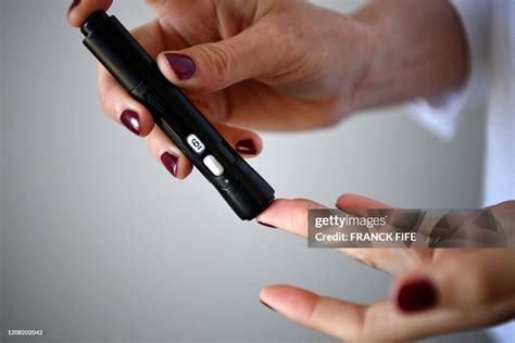 A Woman With Diabetes Pricks Her Finger To Take A Blood Sample To
