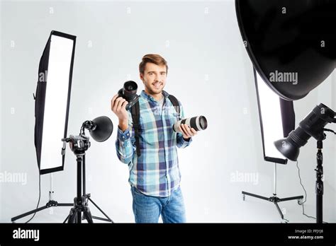 Happy Male Photographer Standing In Photo Studio With Equipments Stock