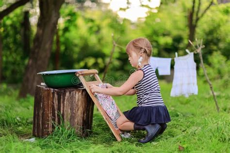 Little Helper Girlwashes Clothes Using The Washboard Outdoors Stock